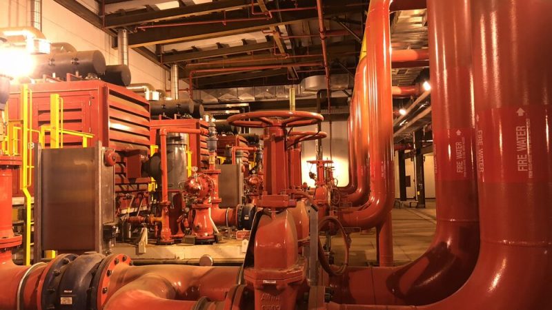 Fire water pump house with red firewater piping and pumps at Suncor