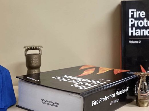 Fire Protection Handbook and sprinkler heads on a Rotaflow desk
