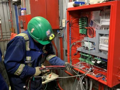 Rotaflow technician servicing a fire alarm control panel